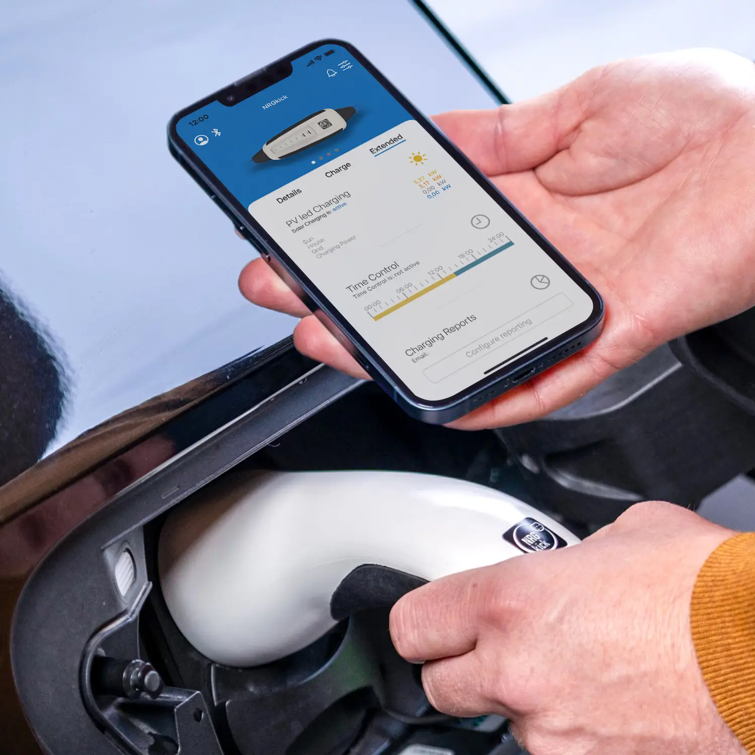 Electric car charges on intelligent NRGkick wallbox, app shows charging status.
