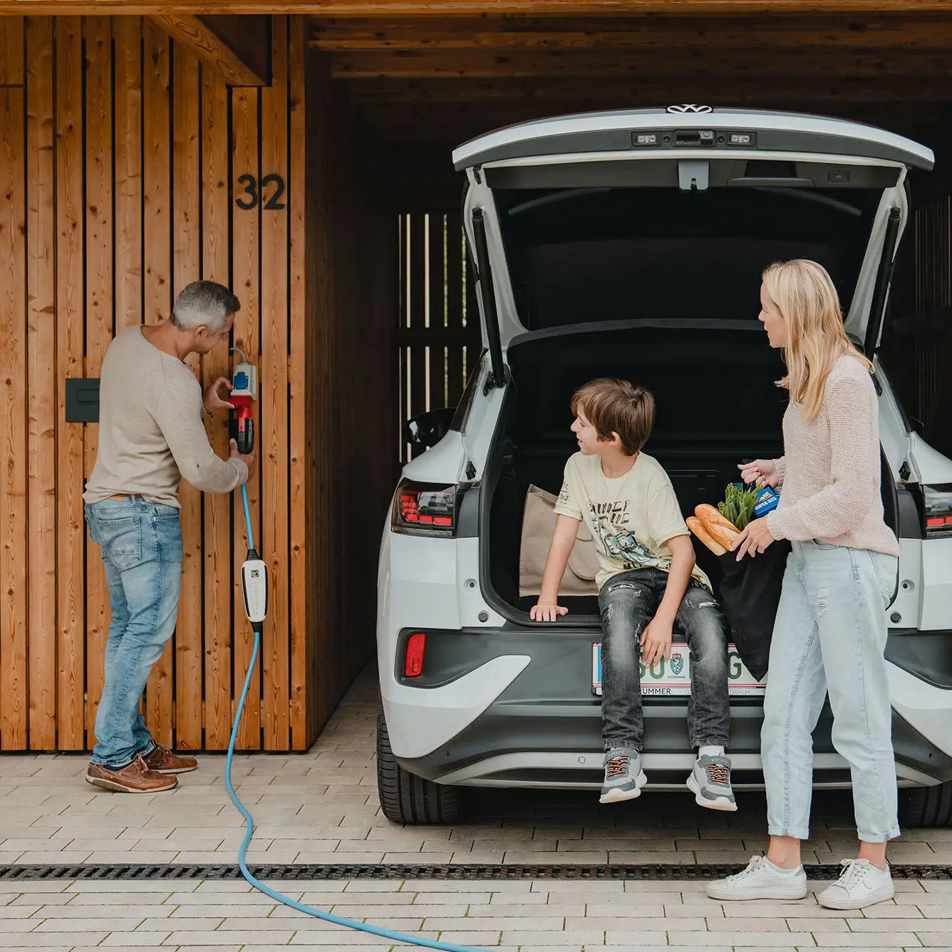 Familie die das E-Auto zuhause lädt.
