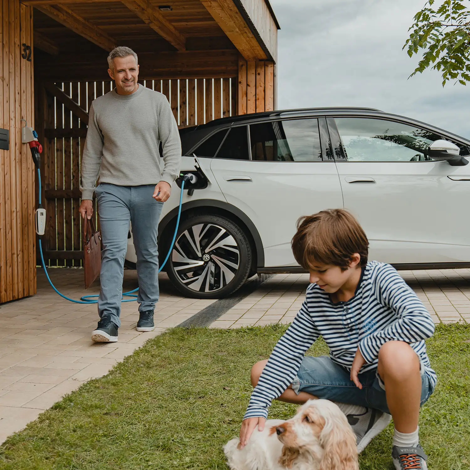 Mann lädt E-Auto sicher zuhause mit der mobilen Wallbox-NRGkick.